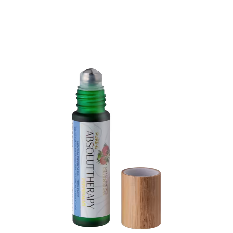 Óleo essencial em frasco de vidro verde com tampa de madeira. O frasco tem um rótulo com o nome "Absolut Therapy" e a marca Kaki Cosmetics. As cores predominantes são verde, branco e marrom claro. Seu aplicador é em formato roll-on.