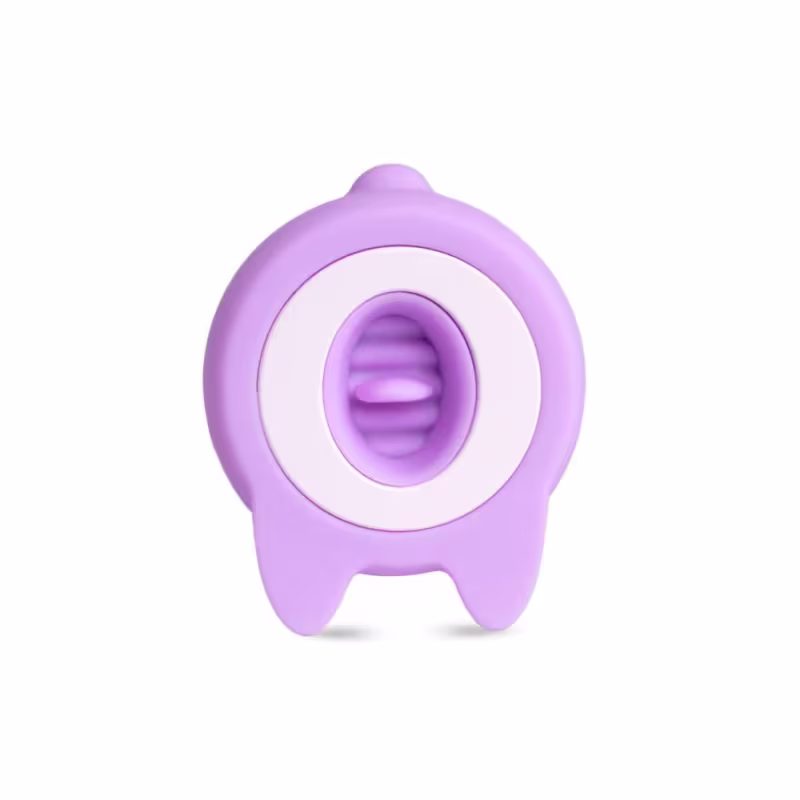 O produto apresentado é um vibrador liilás em formato anatômico, com uma superfície lisa e arredondada. Possui uma abertura central e uma base mais larga na parte inferior.