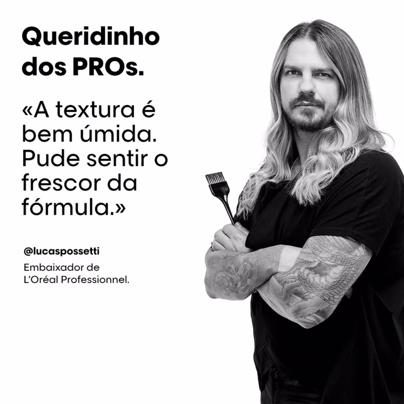 A imagem mostra um homem loiro de cabelos longos e barba, vestindo uma blusa preta. Ele segura um pincel de tinta. O texto destaca um depoimento dele sobre a textura e da fórmula de um produto da linha L'Oréal Professionnel, da qual ele é embaixador.