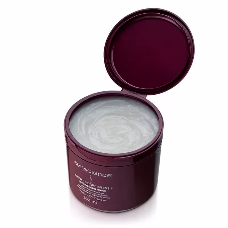 A imagem mostra o pote da máscara aberto, revelando a consistência cremosa e branca do produto.