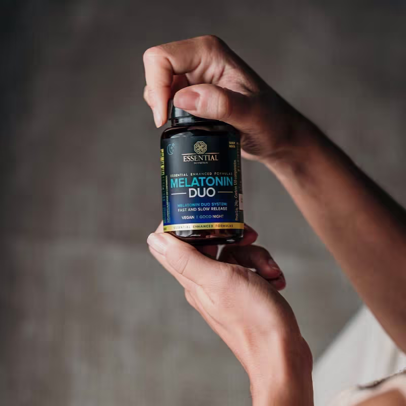 A imagem mostra duas mãos, uma segurando o pote e outra abrindo a tampa.