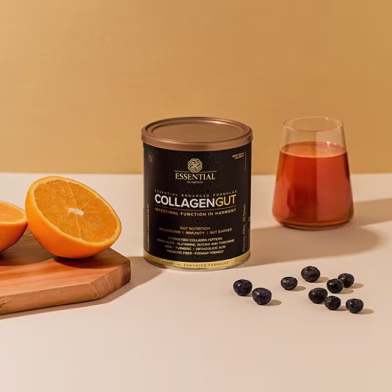 A imagem mostra a lata no centro, ao lado de uma laranja cortada, um copo com a mistura pronta pra beber e blueberrys ao lado da lata.