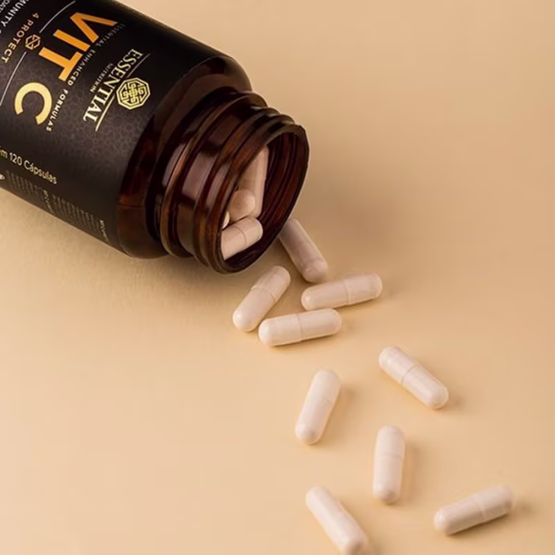 A imagem mostra o pote aberto com as cápsulas caindo numa superfície bege.