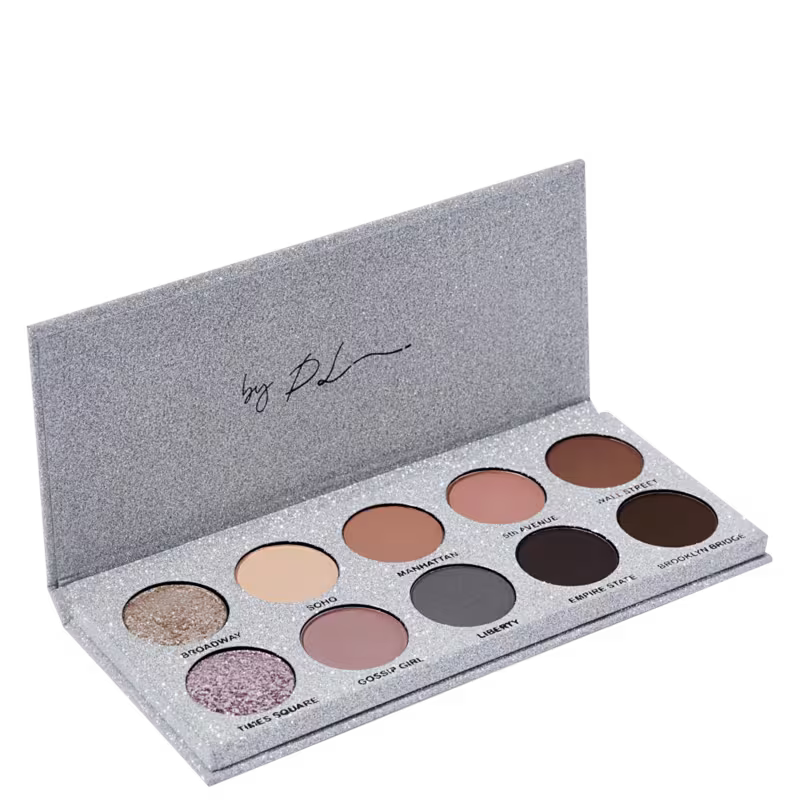 A imagem mostra a paleta de sombras de olhos da marca Ky Beauty. Embalagem retangular de papelão cinza brilhante. Contém 10 sombras prensadas em tons neutros variando do bege claro ao marrom escuro. Apresentação compacta e portátil.