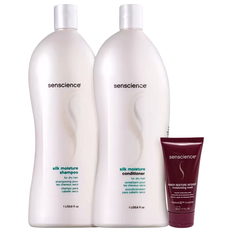 A imagem mostra dois grandes frascos de plástico branco opaco com tampas brancas, contendo shampoo e condicionador. Ao lado, um tubo vinho com a embalagem de uma máscara hidratante da mesma marca.