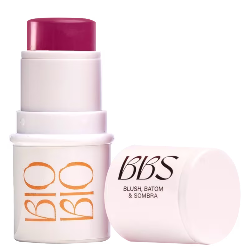 Produto de beleza em embalagem branca e rosa, com rótulo "BBS - Blush, Batom & Sombra". O produto possui formato de bastão, com tampa rosada na parte superior.