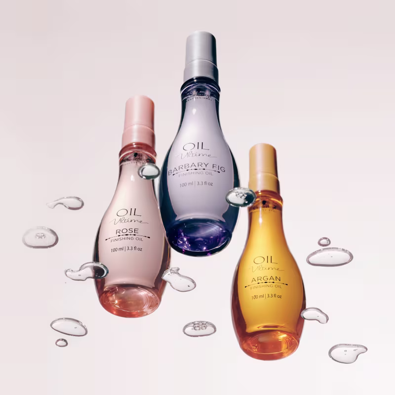 Três frascos de óleos da marca Schwarzkopf Professional: Rose, Barbary Fig e Argan, em embalagens de 100 ml com rótulos em tons de rosa, roxo e amarelo, respectivamente.