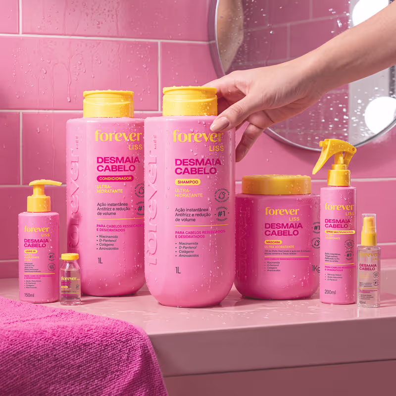 Conjunto de produtos de beleza da marca Forever Liss, incluindo shampoo, condicionador, máscara e spray para cabelos ressecados e desidratados, em embalagens rosa e amarela com rótulos indicando os benefícios do tratamento.