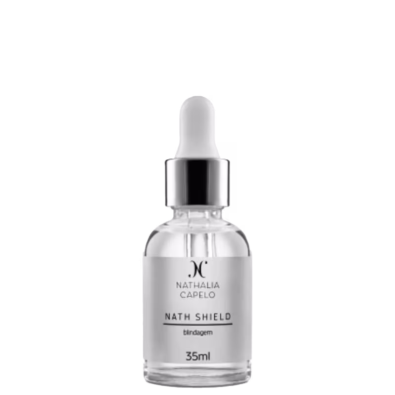 O produto apresentado é um fixador para maquiagem da marca Nathalia Capelo, chamado "Nath Shield". O frasco é de vidro transparente com um conta-gotas na tampa. O volume do produto é de 35ml.