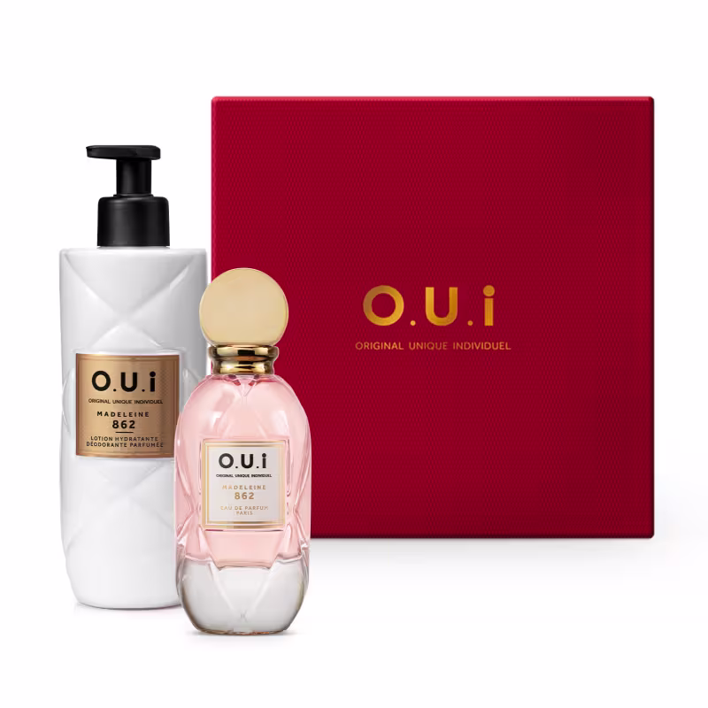 Caixa vermelha com texto "O.U.I" em dourado. Frasco de perfume rosa com rótulo "O.U.I La Parisienne 862" e frasco branco com bomba preta, rótulo "O.U.I Lotion Hydratante Deodorante Parfumee 862". Embalagem e itens de perfumaria em cores contrastantes.
