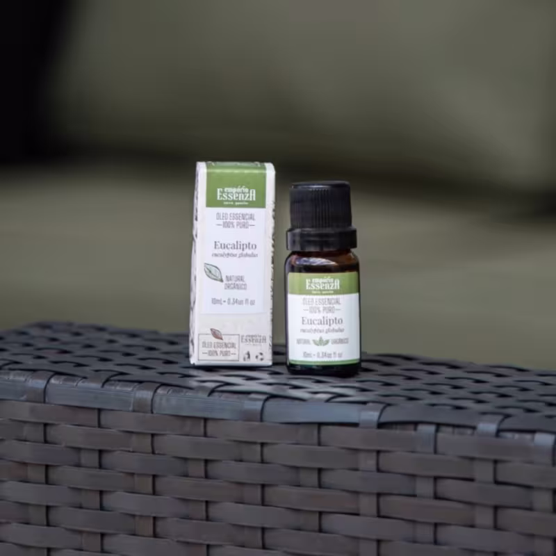 Caixa e frasco de óleo essencial de eucalipto da marca Empório Essenza, com rótulos em verde e preto. O óleo essencial está acondicionado em um frasco de vidro com tampa preta.