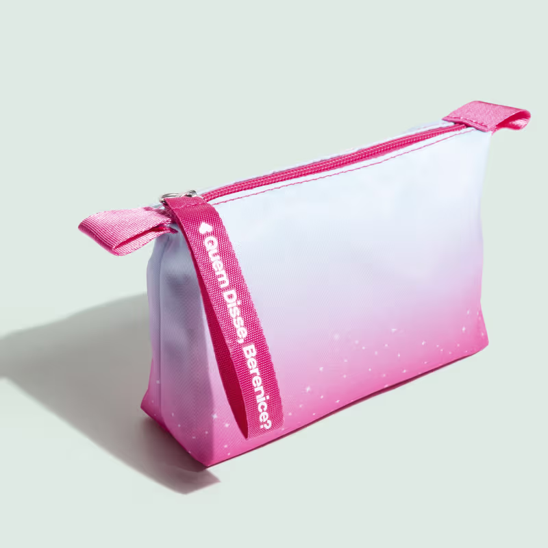 Estojo ou necessaire de maquiagem em formato retangular. Confeccionado em tecido rosa com detalhes degradê. Possui alça de transporte em tecido rosa O produto apresenta um zíper rosa para abertura e fechamento.