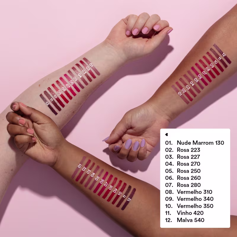 O produto apresentado na imagem é uma paleta de cores para batons. A paleta contém 12 diferentes tons de rosa, vermelho e vinho, com numeração indicando o nome de cada cor. As cores são exibidas em tiras horizontais em 3 braços de cor de pele diferentes