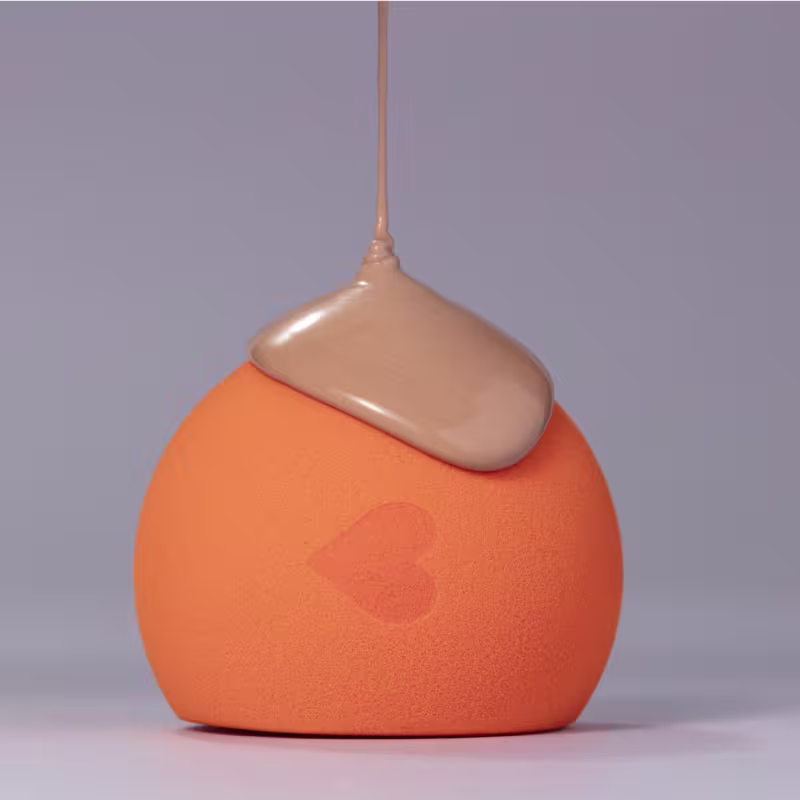 Uma maquiagem líquida sendo derramada sobre a esponja.