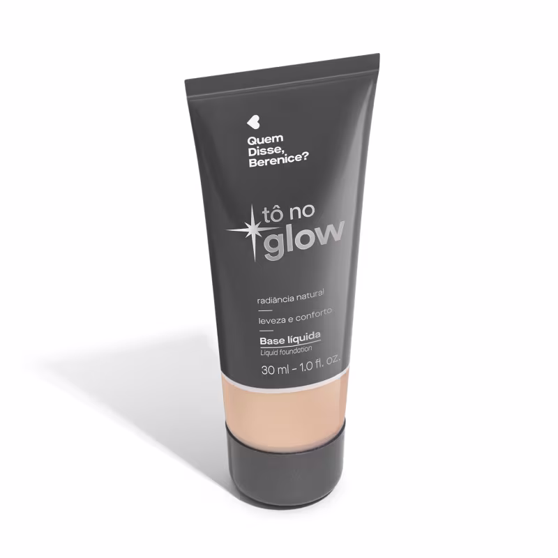 O produto apresentado é uma base líquida da marca Tô no Glow, com embalagem em tubo plástico de cor cinza escura. O rótulo exibe o nome da marca e o texto "Radiância natural, leveza e conforto" em letras brancas.