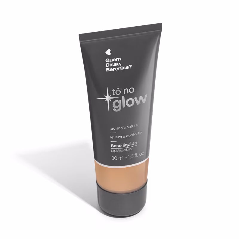 O produto apresentado é uma base líquida da marca Tô no Glow, com embalagem em tubo plástico de cor cinza escura. O rótulo exibe o nome da marca e o texto "Radiância natural, leveza e conforto" em letras brancas.