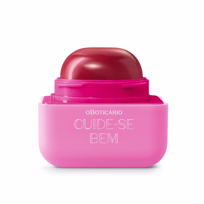 Produto de beleza em embalagem plástica rosa e vermelha. Rótulo na parte inferior rosa com o texto "OBOTICÁRIO CUIDE-SE BEM" em letras brancas.