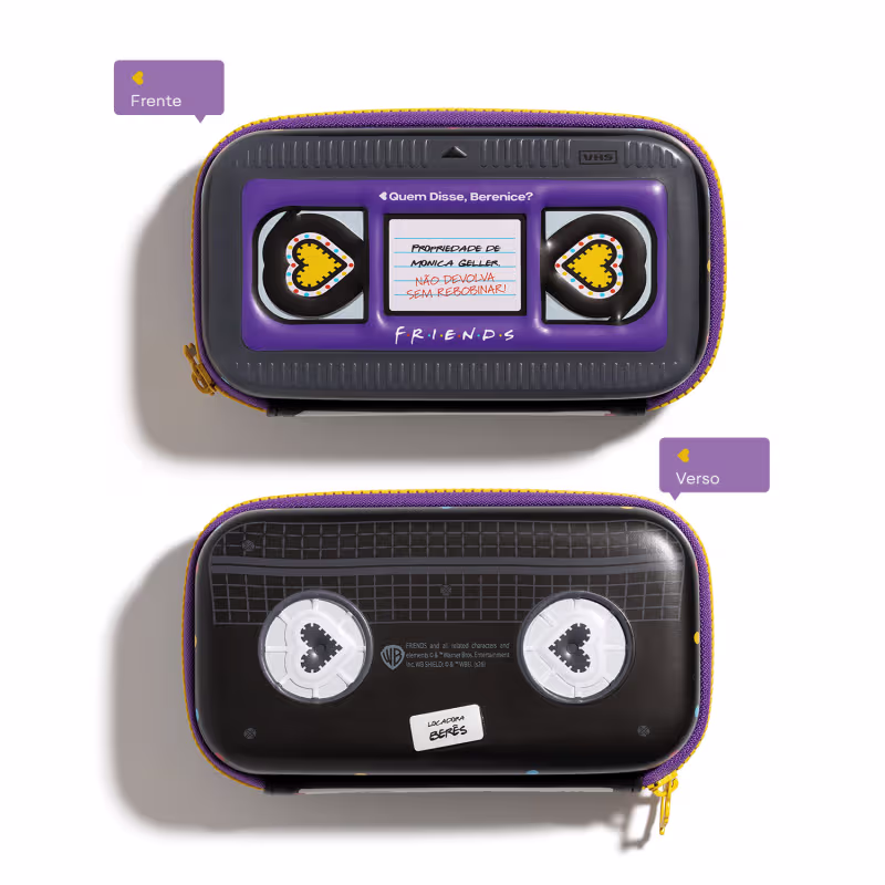 Acessório com design inspirado na série de TV "Friends". Imita fita VHS com uma mensagem sobre não devolver algo sem recarregar. Possui detalhes em roxo e amarelo, com ícones de coração em ambos os lados e no verso do item.