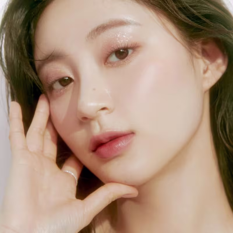 Ambiente de beleza com iluminação suave e tons neutros, destacando o rosto da modelo com maquiagem sutil da marca rom&nd.