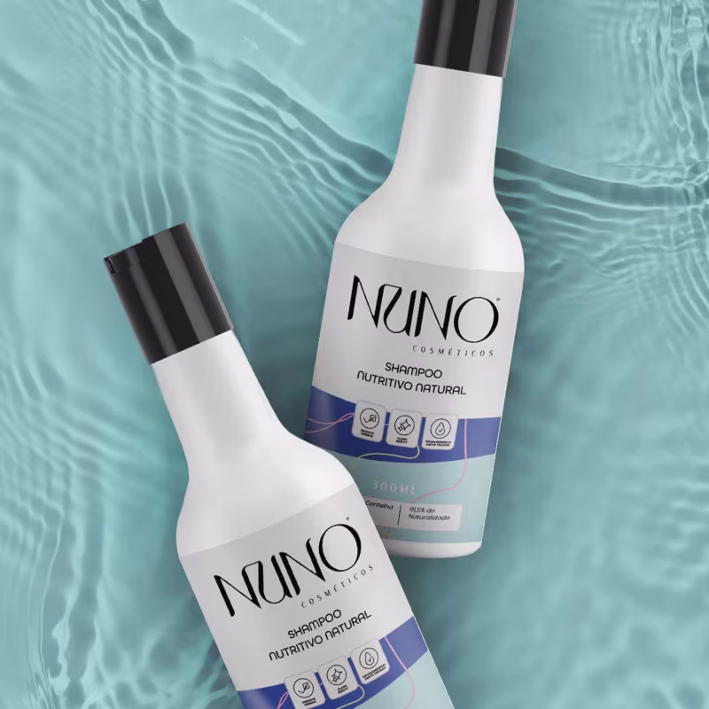 A imagem mostra dois frascos do shampoo sobre um fundo texturizado em tons de azul claro, o que transmite uma sensação clean e natural.