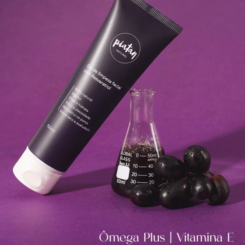 Gel limpeza facial e ao lado frasco de vidro transparente graduado ao lado, com um cacho de uvas pretas. Texto na embalagem indica que é um gel limpeza facial com ingredientes naturais. Cores predominantes são preto, branco e roxo.