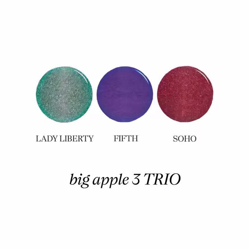 Trio de sombras compactas da marca Big Apple, com as cores Lady Liberty (verde), Fifth (azul) e Soho (vermelho). As sombras são apresentadas em embalagens redondas com os nomes impressos.
