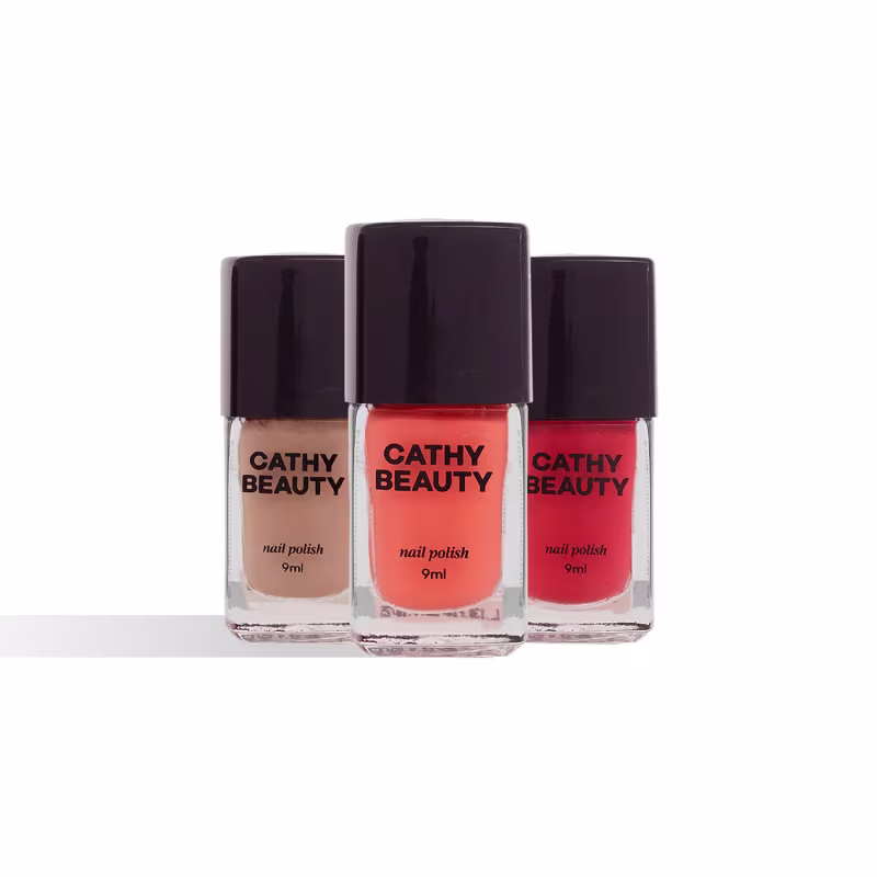 Três frascos de esmalte da marca Cathy Beauty, com cores laranja, vermelha e bege, apresentando rótulos com o nome da marca em destaque.