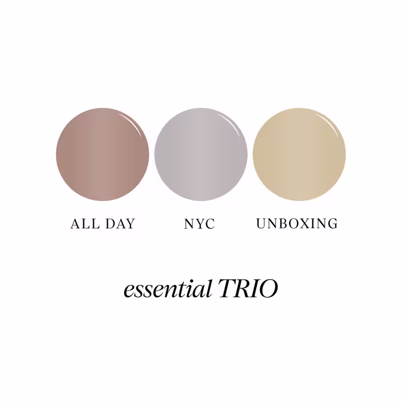 Trio de produtos de beleza da Cathy Beauty, com embalagens redondas nas cores rosa, cinza e bege, exibindo os rótulos "All Day", "NYC" e "Unboxing" respectivamente.