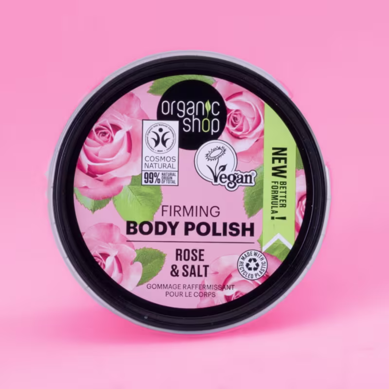 A imagem mostra a tampa do esfoliante corporal em um fundo rosa claro.