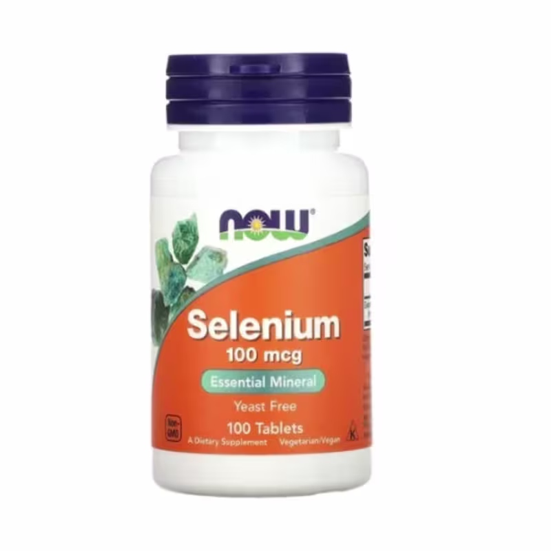 O produto é um suplemento alimentar de selênio da marca Now Foods. É um pote branco com tampa azul escura. O rótulo laranja destaca "Selenium 100 mcg" e "Essential Mineral".  A embalagem apresenta o logotipo da marca Now e uma ilustração de folhas verdes.