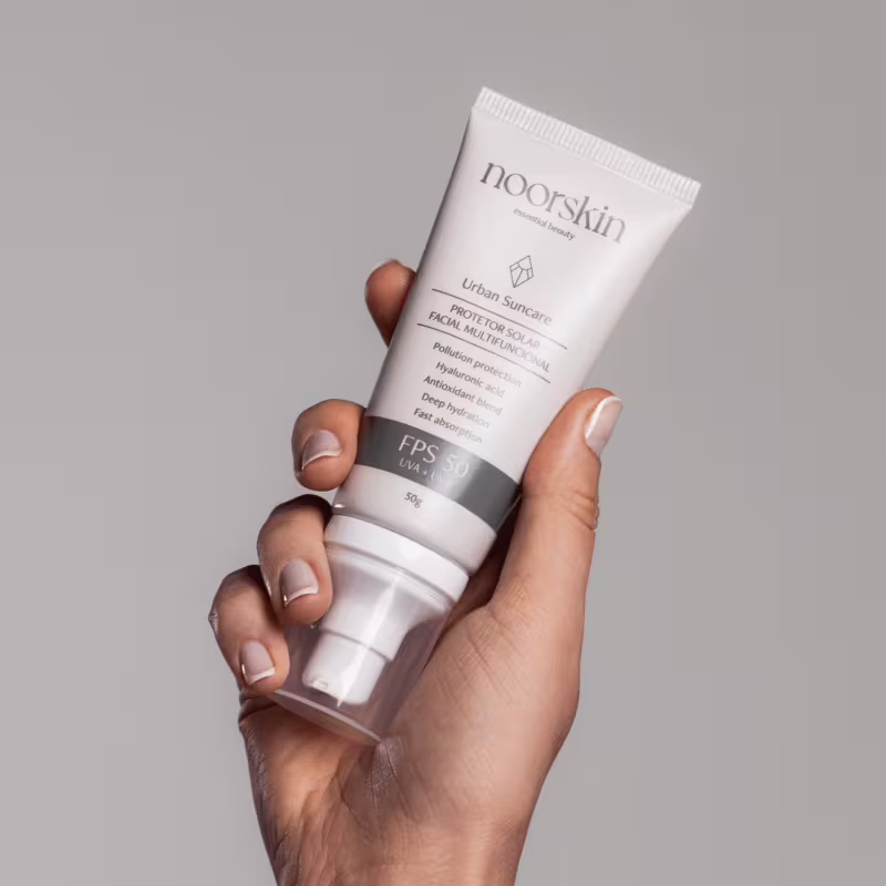 Mão feminina segura o Protetor Solar Facial Noorskin Essential Beauty Urban Suncare FPS 50 50g