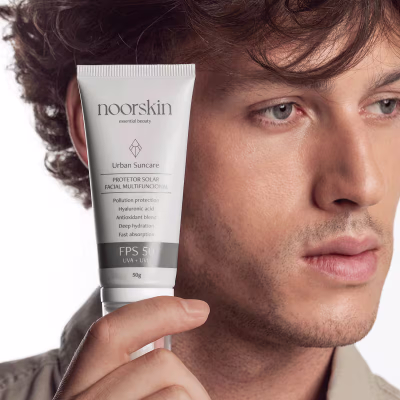 Modelo exibe a embalagem do Protetor Solar Facial Noorskin Essential Beauty Urban Suncare FPS 50 50g