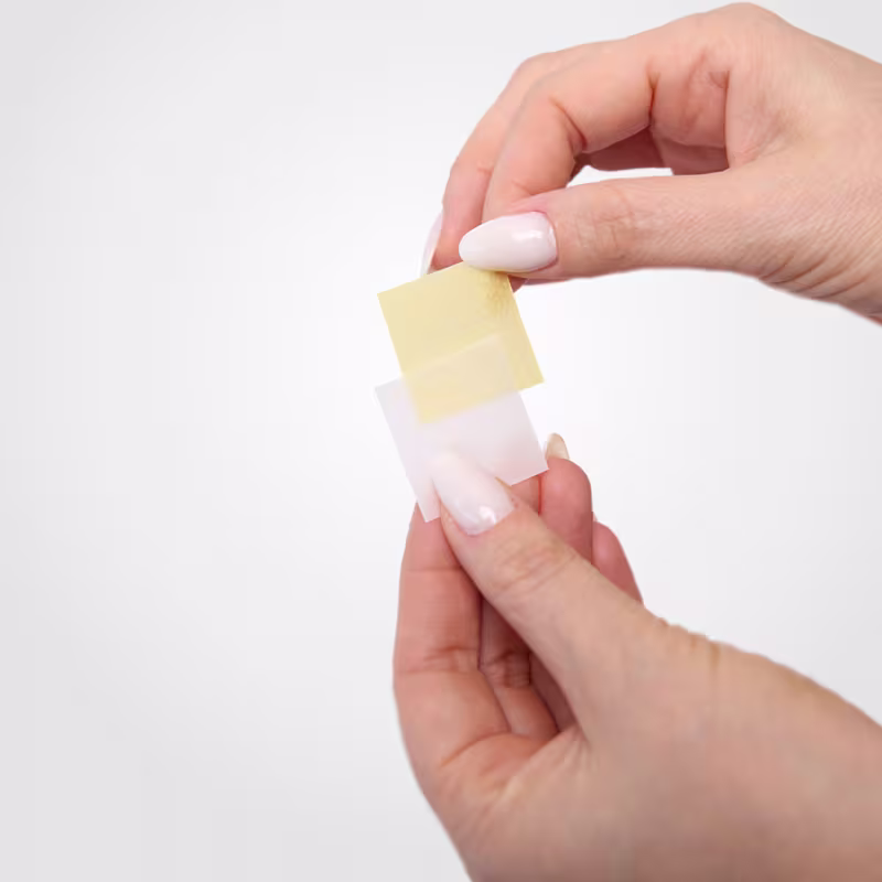 A mão segura o filme Sleeplash da marca Lashes Co.