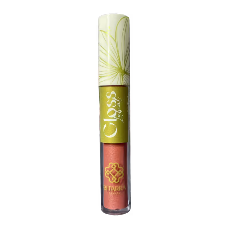Tubo de gloss labial da marca Bitarra Beauty, com embalagem branca e amarela, exibindo um padrão floral estilizado. O rótulo apresenta o nome da marca em destaque.