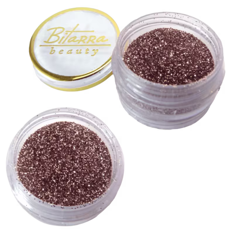 Dois potes de glitter marrom dourdao da marca Bitarra Beauty, conteúdo brilhante e granulado dentro dos recipientes transparentes.