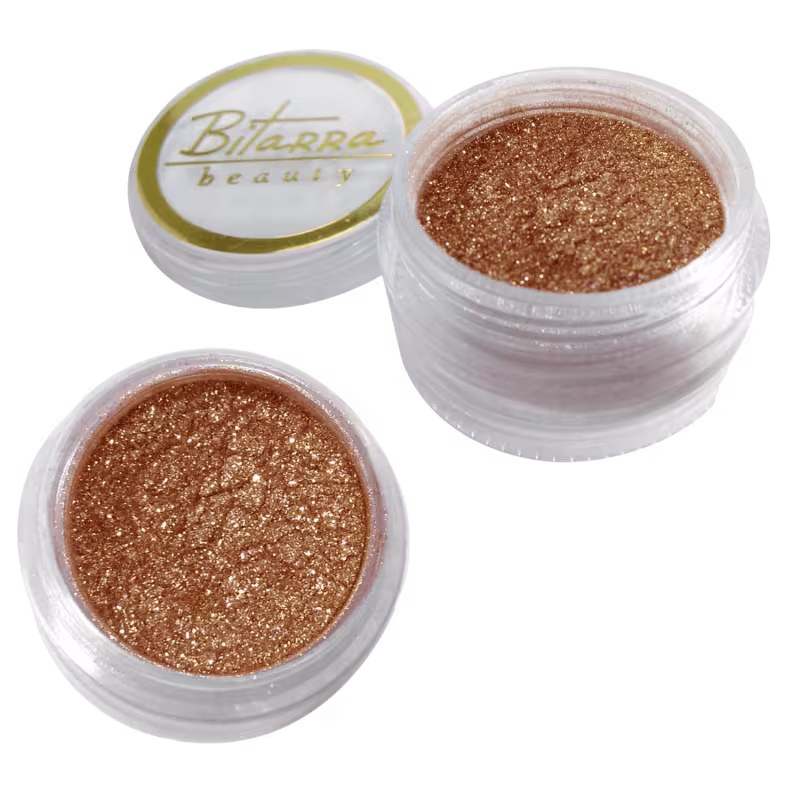 Dois potes de pigmento dourado da marca Bitarra Beauty. Apresenta uma textura brilhante e granulada, em tons de marrom dourado.