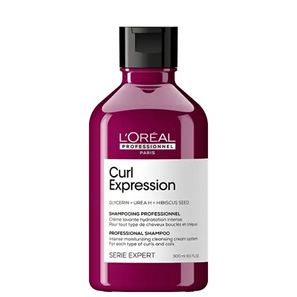 Frasco de shampoo profissional da L'Oréal Paris, da linha Curl Expression, com fórmula à base de glicerina, ureia e semente de hibisco, para cabelos cacheados e ondulados. Embalagem de plástico rígido de cor rosa escuro com rótulo branco e preto.