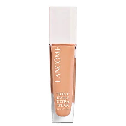 Frasco de maquiagem Lancôme Teint Idole Ultra Wear, com embalagem branca e detalhes em cobre. O produto é descrito como um "Care & Glow" com acabamento natural e duradouro.