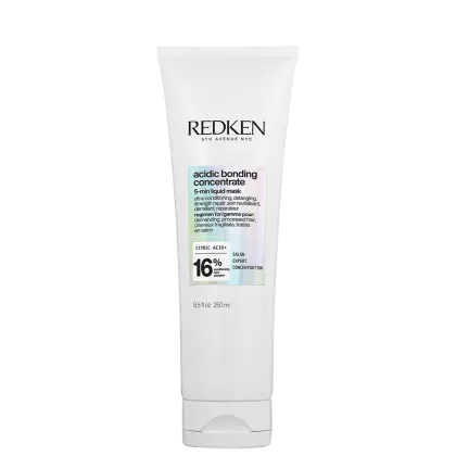 Tubo branco com rótulo preto e azul claro. Texto "Redken 5th Avenue NYC" e "Acidic Bonding Concentrate 5-min Liquid Mask". Informações sobre ingredientes e concentração de ácido cítrico.