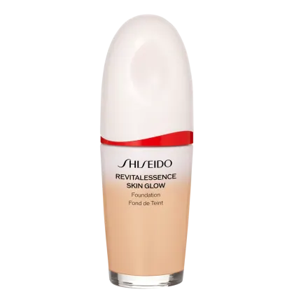 Base facial da marca Shiseido., Embalagem em forma de frasco plástico oval com uma faixa vermelha na parte superior. Rótulo indicando "Revitalessence Skin Glow Foundation" em letras pretas.