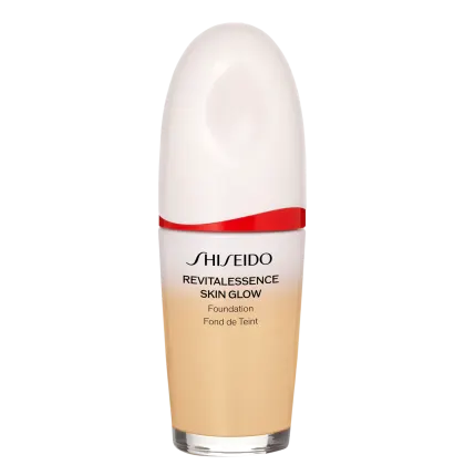 Base facial da marca Shiseido., Embalagem em forma de frasco plástico oval com uma faixa vermelha na parte superior. Rótulo indicando "Revitalessence Skin Glow Foundation" em letras pretas.