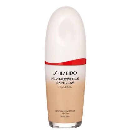 A imagem mostra um frasco de base líquida da marca Shiseido. O produto se chama "RevitaLessence Skin Glow Foundation". Trata-se de uma base com proteção solar SPF 30 e propriedades que prometem dar um brilho saudável à pele (skin glow).
