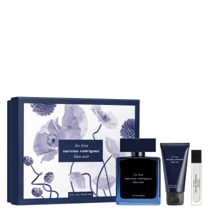 A imagem mostra um conjunto de produtos de perfumaria Narciso Rodriguez. Inclui um frasco azul escuro do perfume, uma caixa de presente com estampa floral azul e branca, um tubo de creme para o corpo e um frasco de perfume em miniatura.