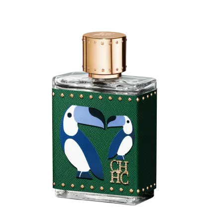 A imagem mostra um frasco de perfume, em formato retangular e feito de vidro transparente, com uma tampa dourada com detalhes e uma capa, cor verde, que cobre o frasco, com detalhes dourados e o desenho de dois pássaros azuis e a logo da marca em dourado.