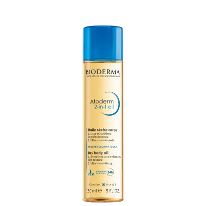 A imagem mostra o óleo corporal de Bioderma Atoderm 2-in-1 Oil. Possui um frasco plástico transparente que permite ver a cor dourada do óleo e uma tampa azul clara. Na parte frontal apresenta informações sobre o óleo em inglês.