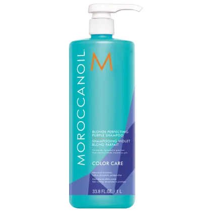 A imagem mostra o Shampoo Moroccanoil Color Care Blonde Perfecting 1L, um frasco cilíndrico azul claro com detalhes em roxo e laranja e aplicador pump branco. De acordo com as informações na embalagem, tem a função de neutralizar os tons amarelados.