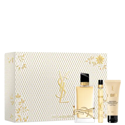 A imagem mostra o conjunto de produtos da linha Libre de Yves Saint Laurent. Mostra o frasco do perfume Libre de 90ml, a versão em miniatura e uma loção corporal de 50ml. Ao lado mostra a caixa especial, branca com detalhes texturizados dourados.