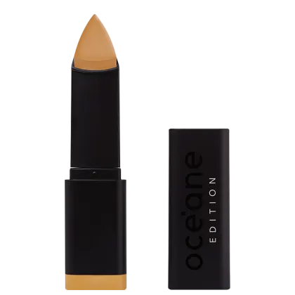 A imagem mostra a Base em Bastão Océane Edition Foundation Stick: embalagem retangular preta com o logotipo "Océane Edition" impresso em relevo na parte frontal. A base tem formato triangular.
