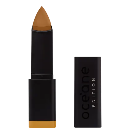 A imagem mostra a Base em Bastão Océane Edition Foundation Stick: embalagem preta retangular com o logotipo "Océane Edition" impresso em relevo na parte frontal. A base tem formato triangular.