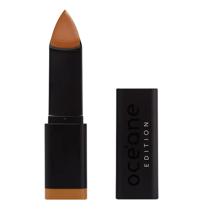 A imagem mostra a Base em Bastão Océane Edition Foundation Stick: embalagem preta retangular com o logotipo "Océane Edition" impresso em relevo na parte frontal. A base tem formato triangular.